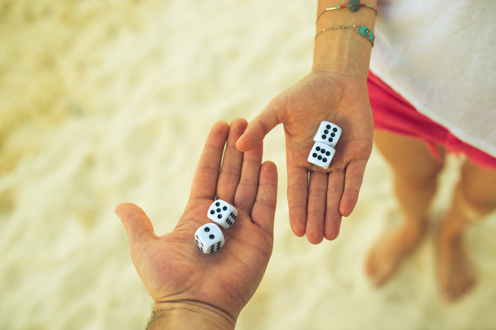 couple playing dice on the beach